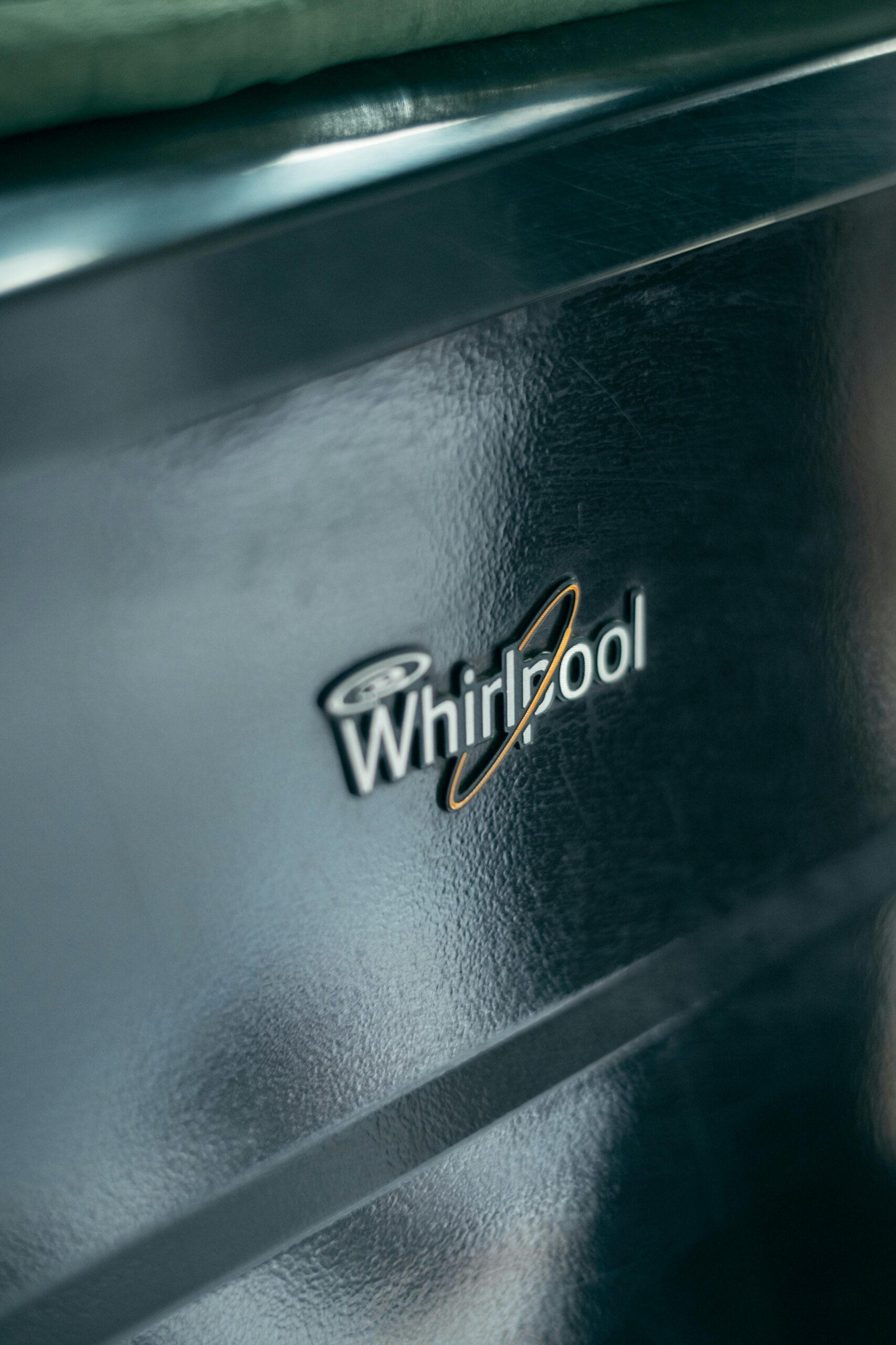Detailed view of Whirlpool logo on metallic kitchen appliance surface.